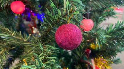 Red ball hanging on the Christmas tree. Decorate Christmas tree.