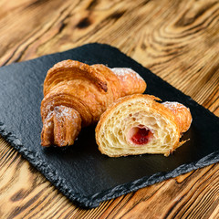cut croissant with filling on a wooden rustic background