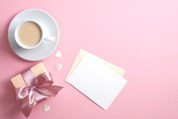 Romantic love letter with blank paper note mockup, gift box with pink ribbon bow, cup of coffee and...