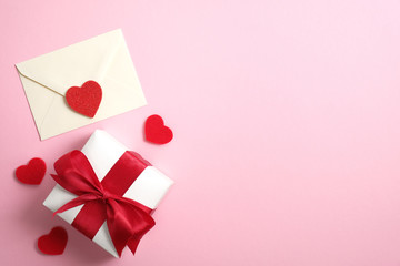 Romantic love letter and gift box with red ribbon on pink background with Valentines hearts. Flat...