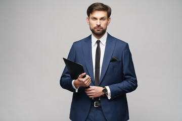 Portrait of a handsome young business man holding folder