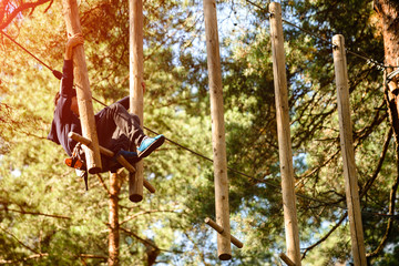 adventure climbing high wire park - people on course in mountain helmet and safety equipment