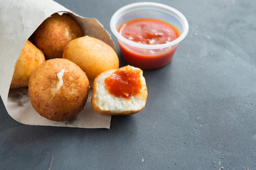 Fried Risotto Arancini stuffed with cheese, served with tomato sauce