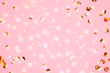 Pink confetti and stars and sparkles on pink background.