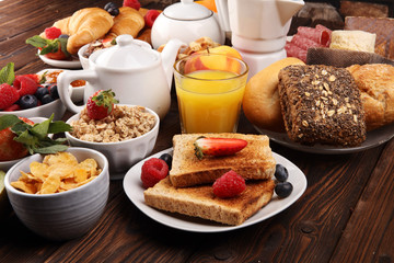 Breakfast served with coffee, orange juice, croissants, cereals and fruits. Balanced diet. Continental breakfast with granola and fruits