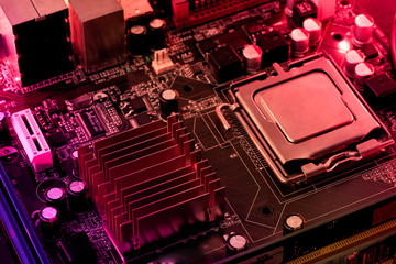 Computer motherboard background with blur neon multicolor glow, pc backdrop, close up