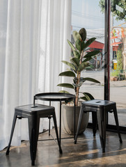 Tables, chairs made of steel with plant pots, decorated, white curtains.  and plaster floors or Loft style. Interior design