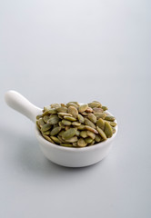 Dry pumpkin seeds in a small cup