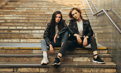 Photo of two models on the stairs of the subway,focused looking at the camera. Two girlfriends in...