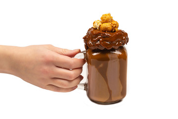 Chocolate milkshake with whipped cream, cookies, waffles, served in glass mason jar. 