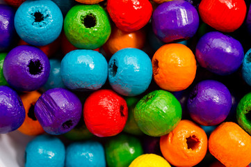 Fototapeta na wymiar Wooden multi-colored beads for the manufacture of jewelry shot large on a white background