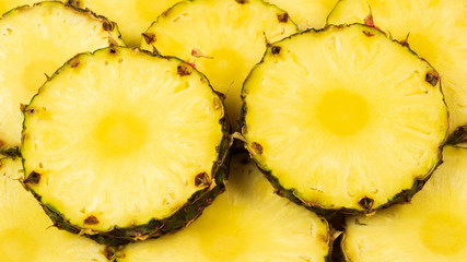 Pineapple juicy yellow slices background. Top view.