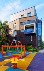 Fototapeta na wymiar Children playing ground at Modern architectural complex of residential buildings reflex
