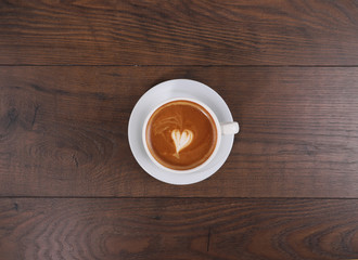 Cup of coffee on the wood table with latte art