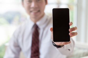 Mock up. Businessman showing a mobile phone with a black screen.