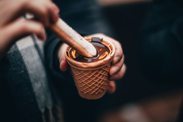 Woman hands eating liquid chocolate on the Chocolate market chocolART in Tübingen, Germany with...