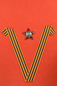 Still life with St. George ribbon in the form of the letter " V "and the order of battle" Red Star "with the inscription" USSR. Proletarians of all countries unite " on a red background.