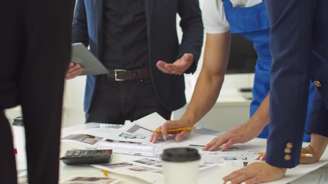 People arrange schemes of apartement on table and calculate