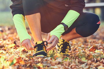 Fototapeta na wymiar Preparing for jogging in autumn colored park.