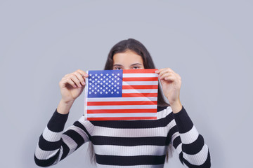 girl holding in hands usa flag and closing part of face