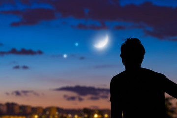 Man looking at the night sky from urban area.