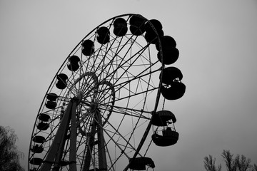 old empty carousel ferris wheel overcast autumn day