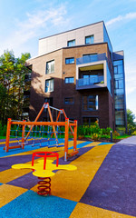 Fototapeta na wymiar Children playing ground at Modern complex of apartment residential buildings reflex