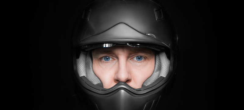 Man In Motorcyclist Helmet On Dark Studio Background. Closeup.