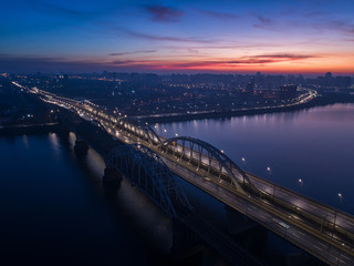 Fototapeta na wymiar Busy traffic on the lantern-lit bridge of the night city.