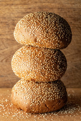 Sesame buns on wooden background, bakery