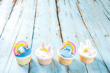 Easter holiday greeting card background. Cute homemade cupcakes with traditional Easter bunny, egg...