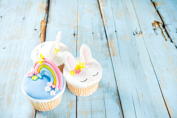 Easter holiday greeting card background. Cute homemade cupcakes with traditional Easter bunny, egg...