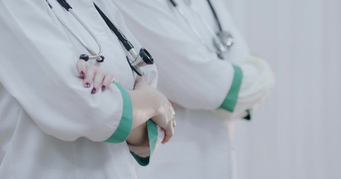 Two Female doctor with stethoscope, hands crossed. Ready to receive patient and help. Medical concept.