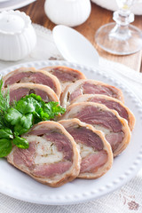 Cooked pork knuckle roll with chicken on a white plate, selective focus