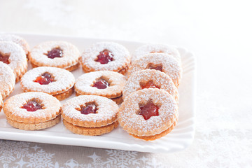 Traditional Christmas linzer cookies on a white dish, horizontal