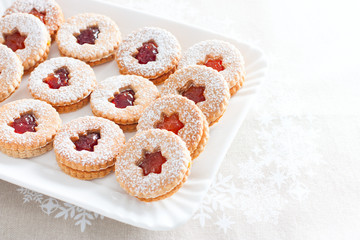 Traditional Christmas linzer cookies on a white dish, horizontal