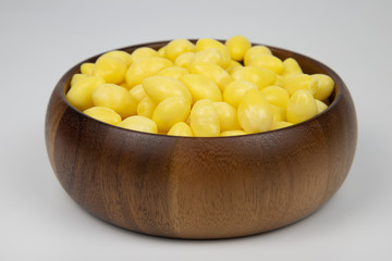 Ginkgo nuts in wooden bowl on white background