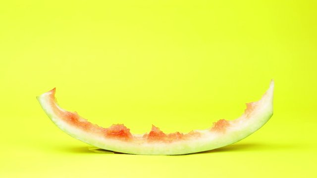 Eaten watermelon slice stop motion animation on yellow background. Summer time fruit.	