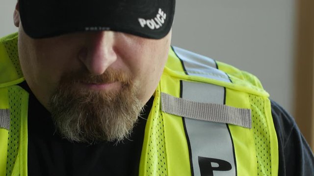 Police officer putting on a traffic vest