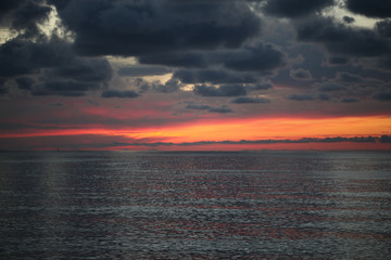 Obraz premium Sunset in the sea with dark clouds.