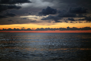 Sunset in the sea with dark clouds.