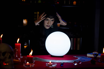 Beautiful young Asian woman Gypsy Fortune teller glowing crystal ball, tarot cards and composition...