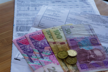 Obraz na płótnie Canvas Ukrainian money hryvnia and coins penny wooden background, utility bill.