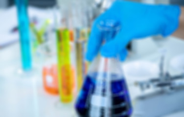 Blur abstract background concept of medical, chemicals or scientific laboratory research and Innovation in the laboratory. experienced man scientist is performing work in the laboratory.