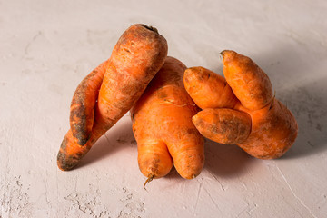 ugly vegetables, carrots on a light background.funny monster carrot The concept of non-waste production in the food industry