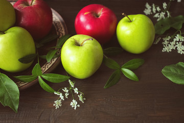 fresh green and red apples. apples on the table and in a plate close-up. background with ripe apples.