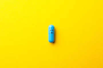 Papier Peint photo autocollant Pharmacie Comprimé en capsule avec visage heureux sur fond jaune, espace pour le texte
