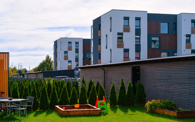 Fototapeta na wymiar New residential apartment house building with children playground reflex