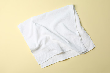 Fresh white towel on beige background, top view