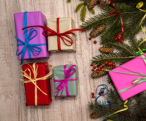 Christmas presents concept. Fir branches with cones and colorful gift boxes on table